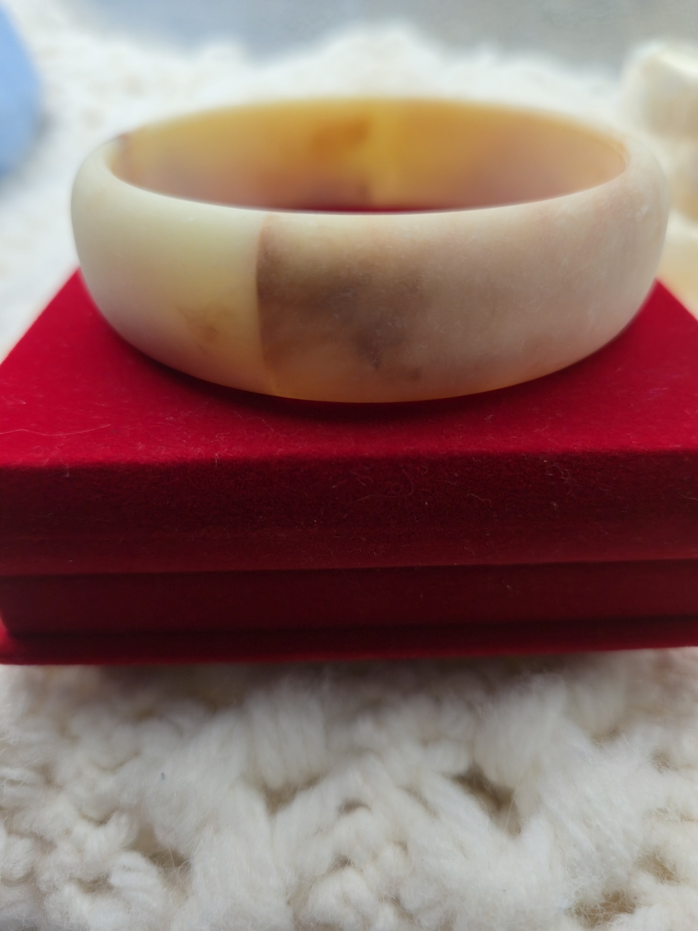 beige and mottled bangle resembles acrylic resin jewelry with a marbled texture.